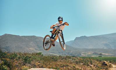 Image showing Mountain bike, cycle and air with a sports man jumping outdoor while riding on a track for adrenaline. Fitness, sky and risk with a male athlete taking a ride on his bicycle for freedom or adventure
