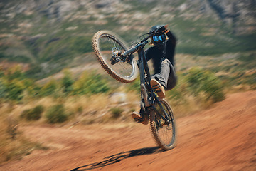 Image showing Cycling, training and person on a bicycle in the countryside for extreme sport, adrenaline and fun. Speed, action and cyclist on a dirt road for stunt, trick or fitness, freedom and balance in nature