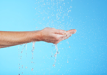 Image showing Woman hands, cleaning and water in a studio for skincare, safety and healthcare from virus. Isolated, blue background and hand wash for hygiene wellness and sanitary protection with liquid stream