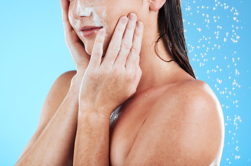 Image showing Woman face cleaning, shower water and studio with a young female hands doing skincare. Bathroom, dermatology beauty and facial treatment of a model hand with mock up and isolated blue background