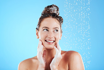 Image showing Haircare, shower and woman in a studio with a beauty, wellness and healthy self care routine. Happy, smile and female model washing her hair with shampoo and water while isolated by a blue background