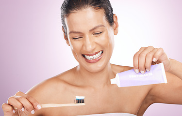 Image showing Smile, woman and bamboo toothbrush and toothpaste in studio isolated on a purple background. Eco friendly, cleaning and happy mature female brushing teeth with natural wooden brush for dental hygiene