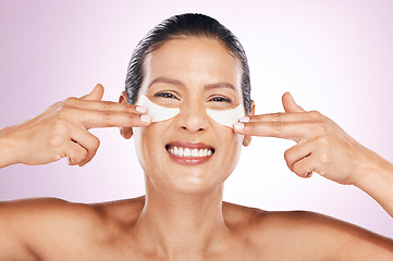 Image showing Face, skincare and woman with eye patches in studio isolated on a purple background. Collagen cosmetics, dermatology and happy, portrait and mature female model apply mask for anti aging treatment.