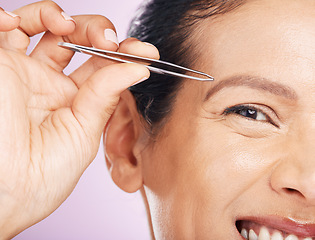 Image showing Woman with tweezers for plucking eyebrows in studio for mature facial hair removal routine. Self care, grooming and closeup of female model tweezing for face epilation treatment by purple background.