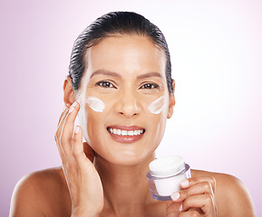 Image showing Face, cream jar and skincare of woman in studio isolated on a purple background. Mature, portrait and happy female apply dermatology lotion, creme product and moisturizer cosmetics for healthy skin.