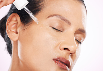 Image showing Face, skincare serum and woman with eyes closed in studio isolated on a purple background. Dermatology, cosmetics and mature female model apply hyaluronic acid, retinol or essential oil for antiaging