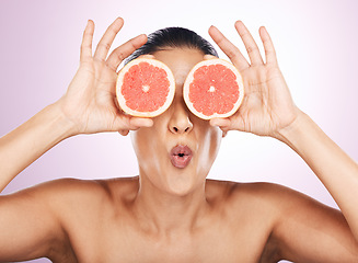 Image showing Face kiss, grapefruit and skincare of woman in studio isolated on a purple background. Natural cosmetics, food and female model with fruit for vitamin c, nutrition or healthy diet, wellness or beauty