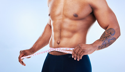 Image showing Black man, fitness and body, measuring tape and abs with health, weight loss and active lifestyle on blue background. Shirtless male bodybuilder, exercise and wellness with diet, healthy and strong