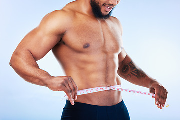 Image showing Black man, exercise and body, weightloss and measuring tape with health and active lifestyle on blue background. Shirtless male bodybuilder, abs and fitness with diet, healthy and strong in studio