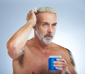 Image showing Hair care, grooming and mature man with gel isolated on a blue background in studio. Beauty, clean and a senior man with a product for styling, hairstyle and applying balm for a hairdo on a backdrop