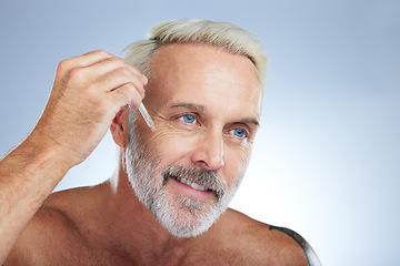 Image showing Old man, smile and facial oil for skincare, beauty and grooming, apply serum on face against studio background. Dropper, anti aging cosmetic care with senior male and mockup, hygiene with dermatology