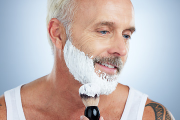 Image showing Senior man, beard and shaving cream for skincare, grooming or hair removal against studio background. Mature male face applying shave creme or foam product with brush for haircare or facial treatment