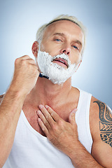 Image showing Senior man, razor and shaving beard with cream for grooming, skincare or hair removal against a studio background. Portrait of mature male with shaver, creme or foam for hygiene or facial treatment