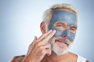 Image showing Elderly man, skin and face mask in studio for health, wellness and organic cleaning with smile by background. Senior model, hand or natural charcoal product for facial cosmetics for dermatology detox