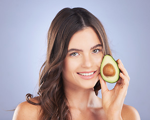 Image showing Woman, avocado and skincare in studio portrait with smile, organic cosmetics and nutrition for beauty. Girl, model and fruit for cosmetic, skin and natural healthy glow with pride by blue background