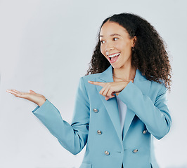 Image showing Business woman, pointing and studio with palm for mockup, promotion or space by white background. Happy entrepreneur, smile and open hand for product placement, mock up or happiness for company promo