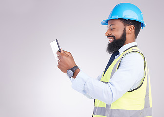 Image showing Tablet, construction and building with an engineer black man in studio on gray background for architecture. Internet, research and project management with a male handyman or contractor in engineering