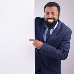 Image showing Business portrait, black man and pointing to board in studio, white background and mockup space. Happy corporate worker, model and advertising poster, marketing news sign and brand on mock up banner