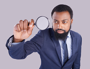 Image showing Business black man, magnifying glass and studio with focus for quality inspection, compliance and stop fraud. Businessman, inspector and auditor at company with attention for financial health at job