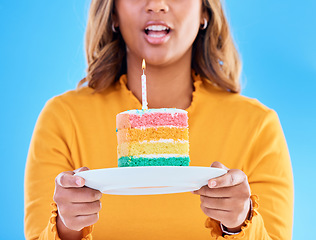 Image showing Birthday cake, celebration and blowing a candle to celebrate a gift or present isolated in a studio blue background. Dessert, sweet and woman or person excited, happiness and happy for festive