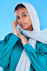 Image showing Muslim, woman and serious portrait in studio, blue background and color backdrop. Young female model, islamic culture and beauty of empowerment, proud religion and arabic fashion of elegant hijab