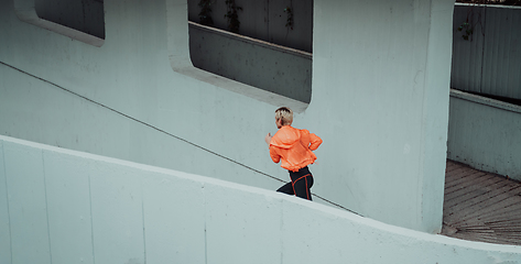 Image showing Women in sports clothes running in a modern urban environment. The concept of a sporty and healthy lifestyle