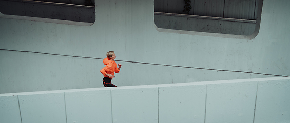 Image showing Women in sports clothes running in a modern urban environment. The concept of a sporty and healthy lifestyle