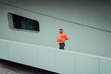 Image showing Women in sports clothes running in a modern urban environment. The concept of a sporty and healthy lifestyle