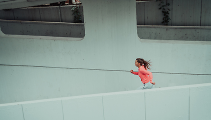 Image showing Women in sports clothes running in a modern urban environment. The concept of a sporty and healthy lifestyle