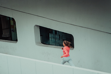 Image showing Women in sports clothes running in a modern urban environment. The concept of a sporty and healthy lifestyle