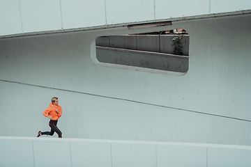 Image showing Women in sports clothes running in a modern urban environment. The concept of a sporty and healthy lifestyle