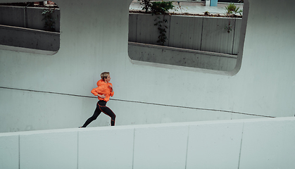 Image showing Women in sports clothes running in a modern urban environment. The concept of a sporty and healthy lifestyle