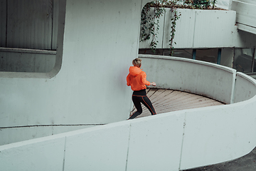 Image showing Women in sports clothes running in a modern urban environment. The concept of a sporty and healthy lifestyle