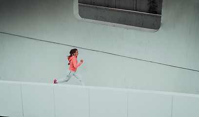 Image showing Women in sports clothes running in a modern urban environment. The concept of a sporty and healthy lifestyle