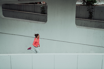 Image showing Women in sports clothes running in a modern urban environment. The concept of a sporty and healthy lifestyle