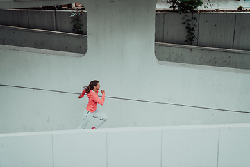 Image showing Women in sports clothes running in a modern urban environment. The concept of a sporty and healthy lifestyle