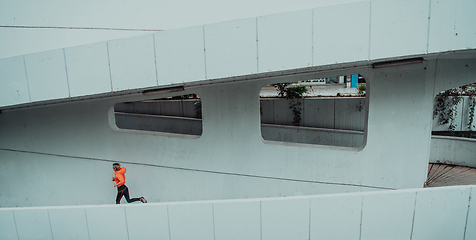 Image showing Women in sports clothes running in a modern urban environment. The concept of a sporty and healthy lifestyle