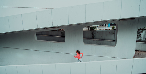 Image showing Women in sports clothes running in a modern urban environment. The concept of a sporty and healthy lifestyle