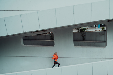 Image showing Women in sports clothes running in a modern urban environment. The concept of a sporty and healthy lifestyle