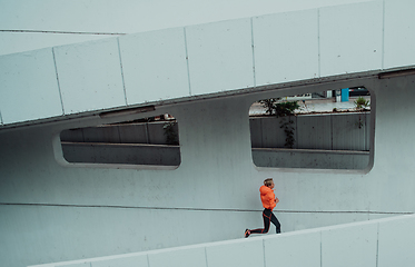 Image showing Women in sports clothes running in a modern urban environment. The concept of a sporty and healthy lifestyle