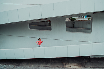 Image showing Women in sports clothes running in a modern urban environment. The concept of a sporty and healthy lifestyle