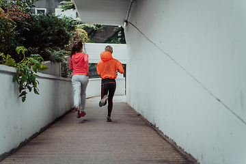 Image showing Two women in sports clothes running in a modern urban environment. The concept of a sporty and healthy lifestyle