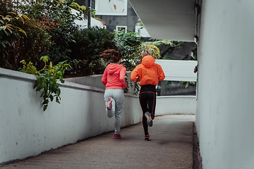 Image showing Two women in sports clothes running in a modern urban environment. The concept of a sporty and healthy lifestyle