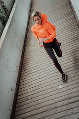 Image showing Women in sports clothes running in a modern urban environment. The concept of a sporty and healthy lifestyle