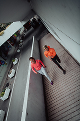 Image showing Two women in sports clothes running in a modern urban environment. The concept of a sporty and healthy lifestyle