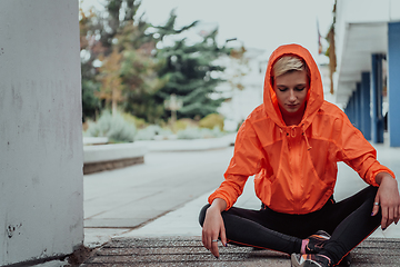 Image showing Young smiling female resting after an active fitness training