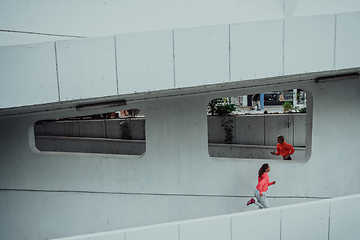 Image showing Two women in sports clothes running in a modern urban environment. The concept of a sporty and healthy lifestyle