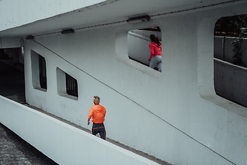 Image showing Two women in sports clothes running in a modern urban environment. The concept of a sporty and healthy lifestyle