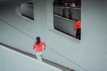 Image showing Two women in sports clothes running in a modern urban environment. The concept of a sporty and healthy lifestyle