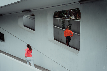 Image showing Two women in sports clothes running in a modern urban environment. The concept of a sporty and healthy lifestyle